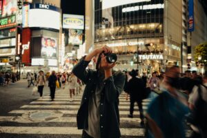 A man taking a picture of a busy city street