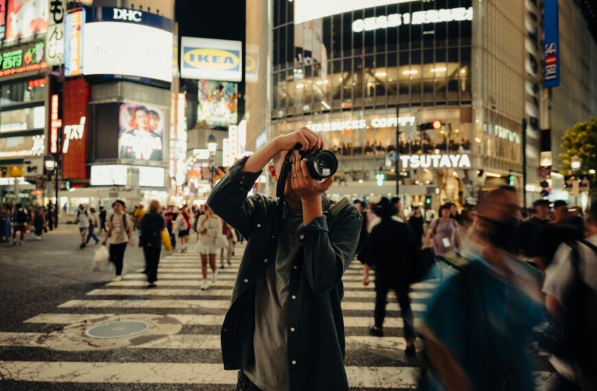 A man taking a picture of a busy city street