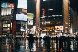 Cityscape at night, full of lights and people.