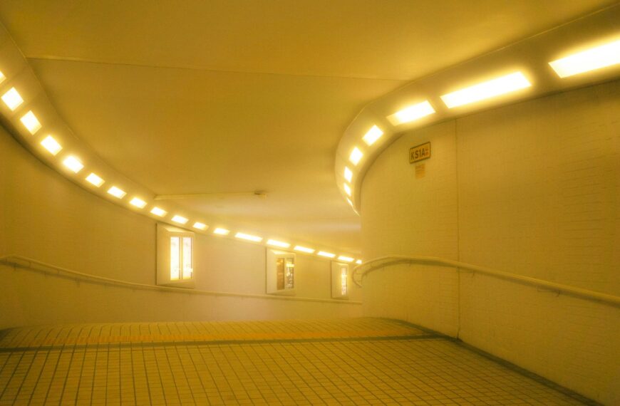A yellow lit tunnel with windows.