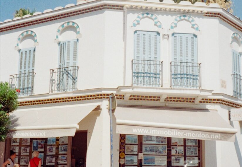 A white building features balconies and storefronts.