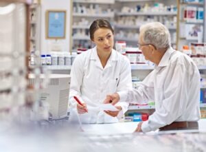 Pharmacist,,Elderly,Man,And,Document,At,Counter,For,Consultation,,Medicine
